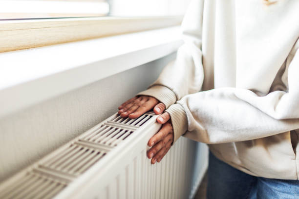 Melbourne homeowner warming hands over gas heater considering switching to electric reverse cycle